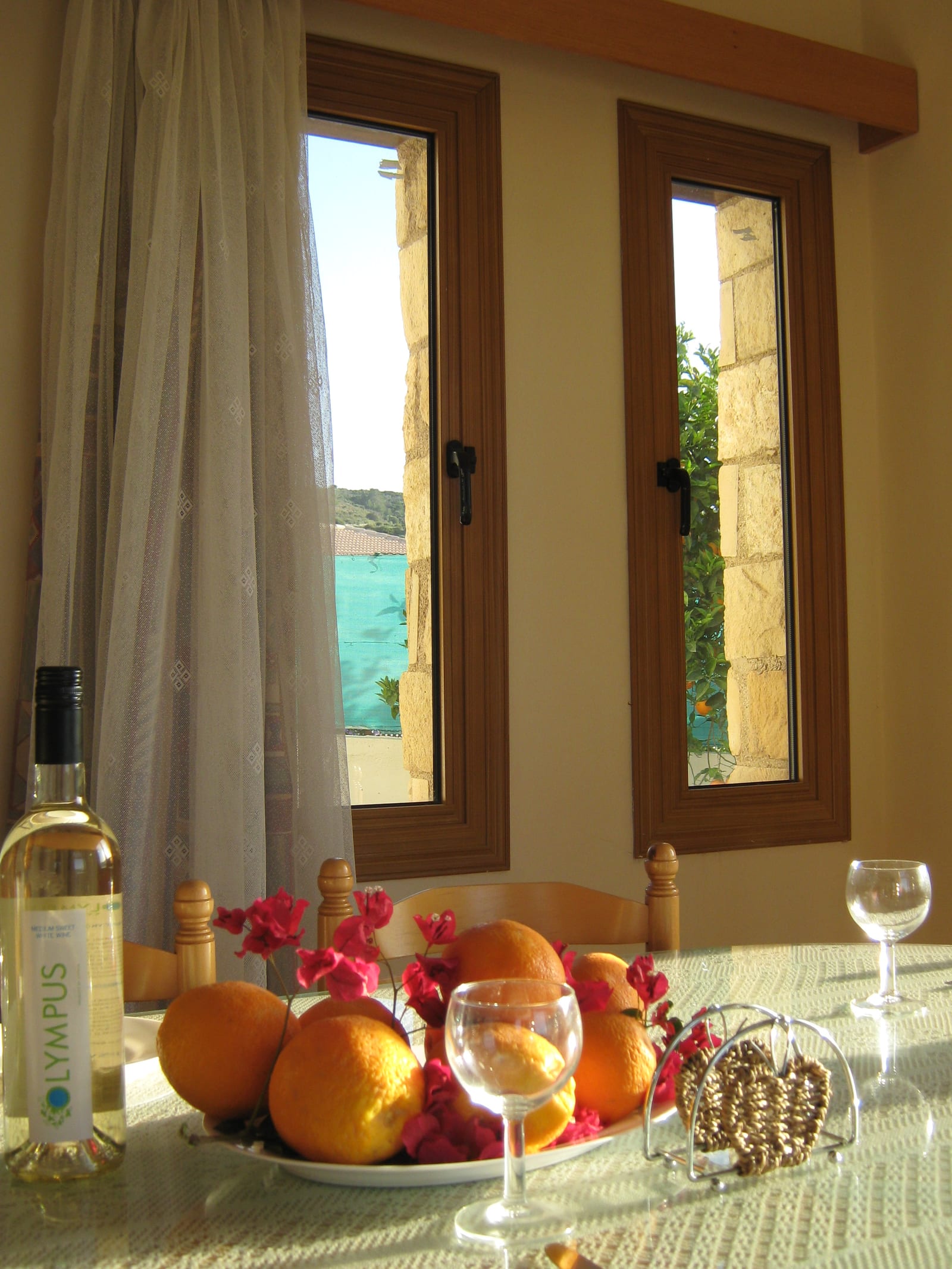 A bowl of oranges and lemons on the dining table, framed by two narrow windows onto the sea